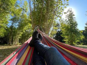 a person laying on a hammock with their feet on it at Bamboo Grove by Tiny Away in Bauple
