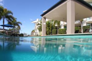 
a swimming pool with a balcony overlooking the ocean at Caloundra Central Apartment Hotel in Caloundra
