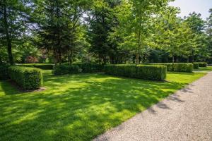a garden with hedges and a path at Camping des Bains in Saint-Honoré-les-Bains