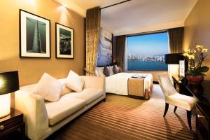 a living room filled with furniture and a large window at Harbour Grand Hong Kong in Hong Kong