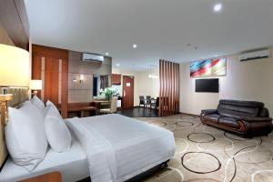 a hotel room with a bed and a living room at Aston Inn Gideon Batam in Nagoya