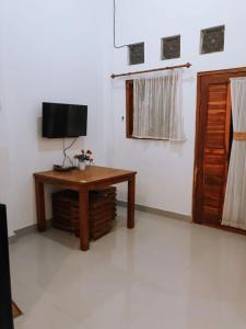 a room with a table and a television in it at Anorawi surf accommodation in Maluk