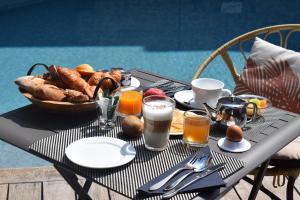 a table with a basket of food and drinks on it at Le Trophée Boutique Hôtel Spa- La Loggia Appart'hôtel in Deauville