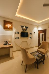 a living room with a tv and a table and chairs at The Mayur Resort # Big Swimming Pool # Luxury Rooms # Garden # Playing Zone # Away From City Hustle # Property Of The Year # By Elegance # in Vrindāvan