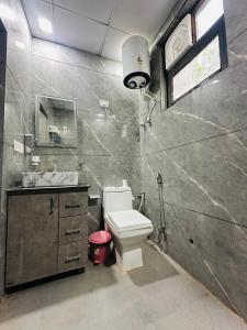 a bathroom with a white toilet and a sink at The Mayur Resort # Big Swimming Pool # Luxury Rooms # Garden # Playing Zone # Away From City Hustle # Property Of The Year # By Elegance # in Vrindāvan +63 photos