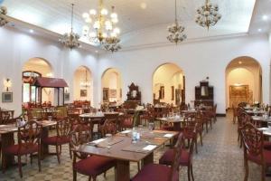 ein Esszimmer mit Tischen, Stühlen und Kronleuchtern in der Unterkunft Kresna Hotel in Wonosobo