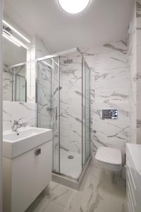 a bathroom with a shower and a toilet and a sink at Symphony City Square Aparthotel by INA in Wrocław