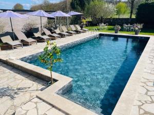 a large swimming pool with chairs and umbrellas at La CHARMILLE PADIRAC in Padirac +84 photos
