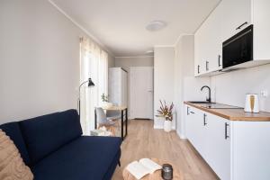 a living room with a blue couch and a kitchen at Symphony City Square Aparthotel by INA in Wrocław +235 photos