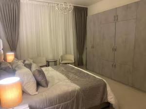 a bedroom with a large bed and a chandelier at Abdali Views Luxury Suite in Al Jafr