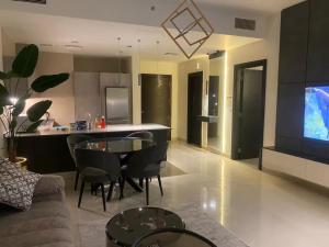 a living room with a couch and a table and a kitchen at Abdali Views Luxury Suite in Al Jafr +1 photo