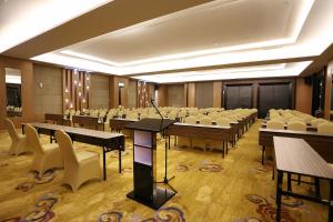 a conference room with tables and chairs and a podium at Horison Tasikmalaya in Tasikmalaya