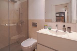 a bathroom with a toilet and a sink and a shower at Stadthaus mit Garten und Dachterrasse -Casa Villanova in Pollença +40 photos