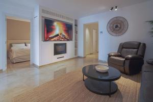a living room with a couch chair and a television at Stadthaus mit Garten und Dachterrasse -Casa Villanova in Pollença