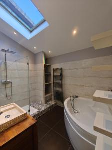 a bathroom with a large tub and a glass shower at Maison Montellier - piscine in Charly +13 photos