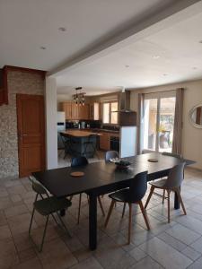 a dining room and kitchen with a table and chairs at Maison Montellier - piscine in Charly