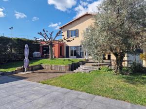 a house with a tree and an umbrella at Maison Montellier - piscine in Charly