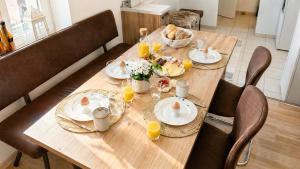 a wooden table with plates of food on it at Komfortable Ferienwohnung 2x Schlafzimmer, Sauna zubuchbar, Parkplatz & Top Lage in Bad Muskau in Bad Muskau