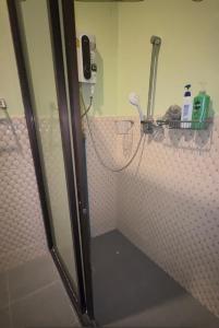 a bathroom with a shower with a phone on the wall at Restaurant Mayuree in Kranuan