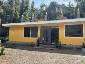 a yellow house with a large window at Twinkle Clouds Home Stay in Chikmagalūr