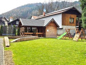 a house with a playground in the yard at Przystań Park Dolny in Szczawnica
