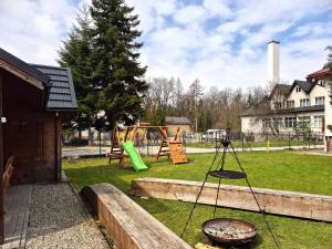 a playground with a swing set in a yard at Przystań Park Dolny in Szczawnica