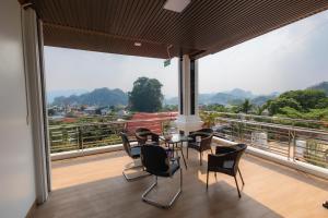 a room with a table and chairs on a balcony at Mộc View House in Mộc Châu