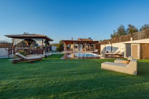a lawn with benches and a gazebo and a pool at SENSEs VILLA SPA in Aghia Marina