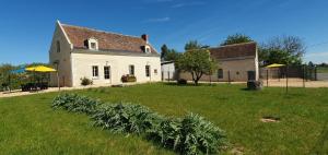 a house with a field of plants in front of it at Fermette et Ecuries Tourangelles in Bréhémont