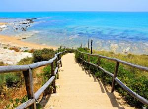 a stairway leading down to a beach with the ocean at Vicolo Re suite in centro con stile in Porto Empedocle