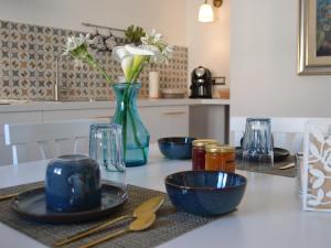 a kitchen counter with blue bowls and a vase with flowers at Turquoise Horizon in Stintino +21 photos
