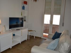 a living room with a couch and a flat screen tv at Turquoise Horizon in Stintino