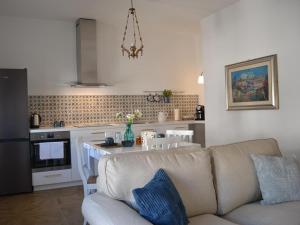 a living room with a couch and a kitchen at Turquoise Horizon in Stintino