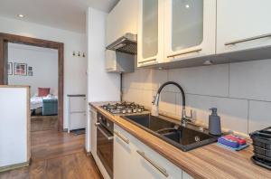 a kitchen with a sink and a stove at Mastalerza Spacious Apartment by BookingHost in Gliwice +17 photos
