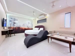a bedroom with a bed and a couch and a table at Hotel Nova Vista in Rajkot