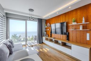 a living room with a couch and a tv at Balticus Apartamenty Promenada Gwiazd 14 in Międzyzdroje