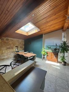 a dining room with a table and a skylight at Le Melchior in Sainte-Terre