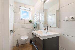 a white bathroom with a sink and a toilet at Backhaus Ost in Bisdorf +6 photos