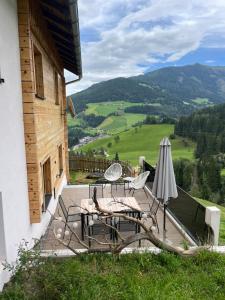 a patio with chairs and a table and an umbrella at Gut Schablberg in Radstadt