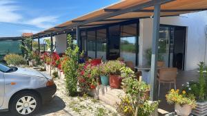 a car parked in front of a house with flowers at Dhoma Pushimi Tale Beach in Lezhë