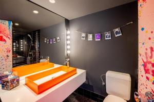 a bathroom with an orange sink and a toilet at nhow Brussels Bloom in Brussels