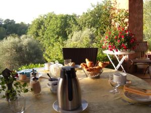 a table with a tea kettle on top of it at Bastide Rose de Mai in Le Rouret
