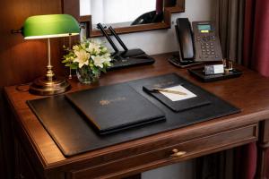 a desk in a hotel room with a lamp and a phone at Eli Suites in Hanoi