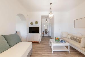 a white living room with a couch and a table at Casa Elena in Aggelika