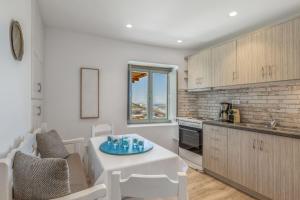 a kitchen and living room with a white table and chairs at Casa Elena in Aggelika