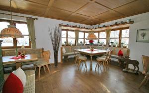 a dining room with a table and chairs and windows at Gästehaus Babel in Pfronten
