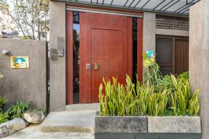 a house with a red door and some plants at 傅棧 Fu Yu in Tainan