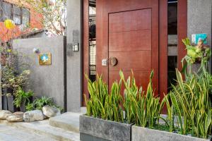 a house with a wooden door and some plants at 傅棧 Fu Yu in Tainan