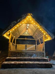 a large straw hut with lights on the stairs at Canopy Haven in Siliguri