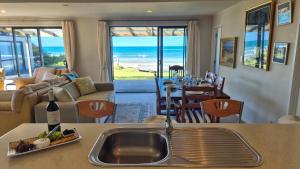 a kitchen and living room with a view of the ocean at Whareupoko in Waimarama